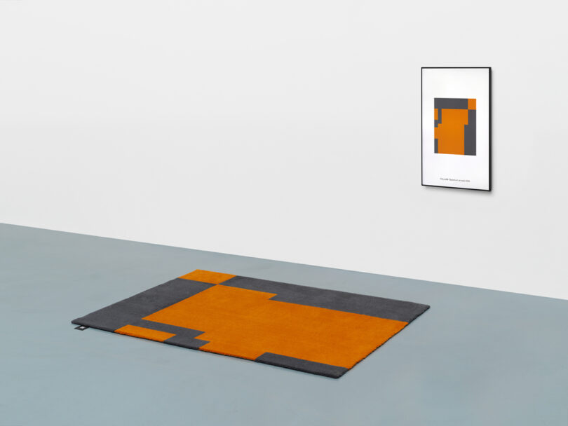 orange and dark grey rug with matching NFT hanging on wall