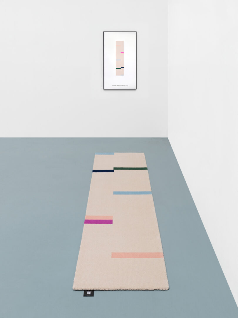 beige, pink, red, light blue, and black runner rug with matching NFT hanging on wall
