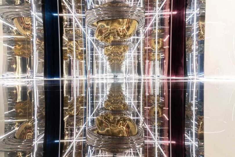 mirrored INTERNA_MENTE installation with gold faces and linear lights