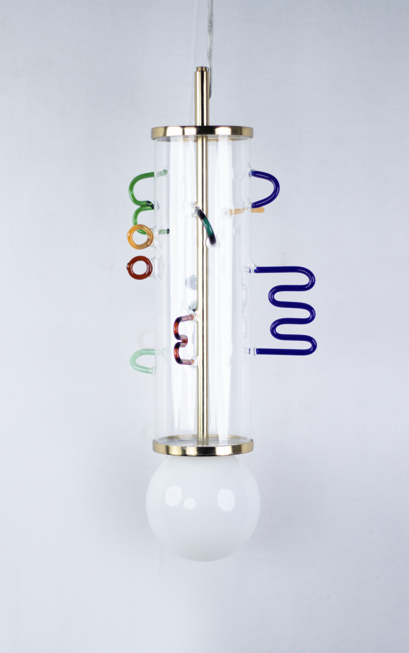 hanging lamp made from a clear glass cylinder with abstract colored shapes of glass attached to the exterior