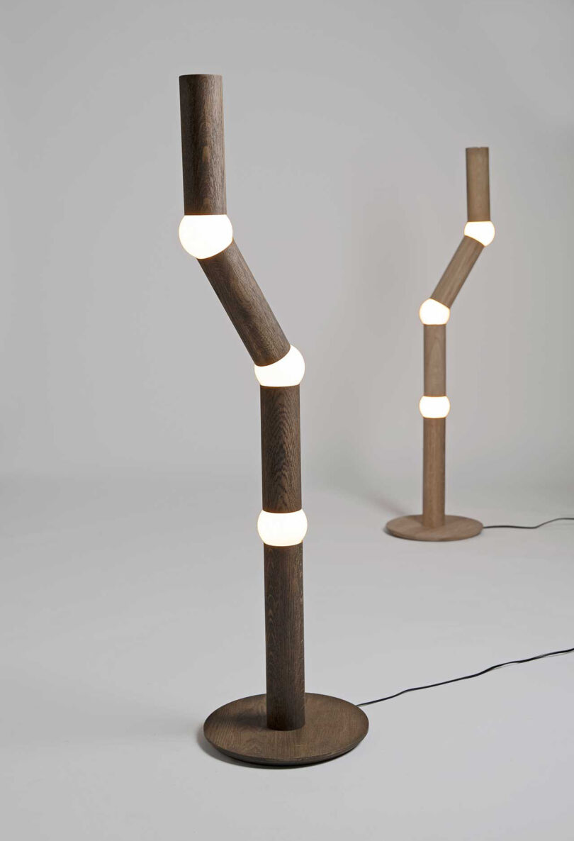 two long, slender floor lamps with four segments, each connected by a round lightbulb