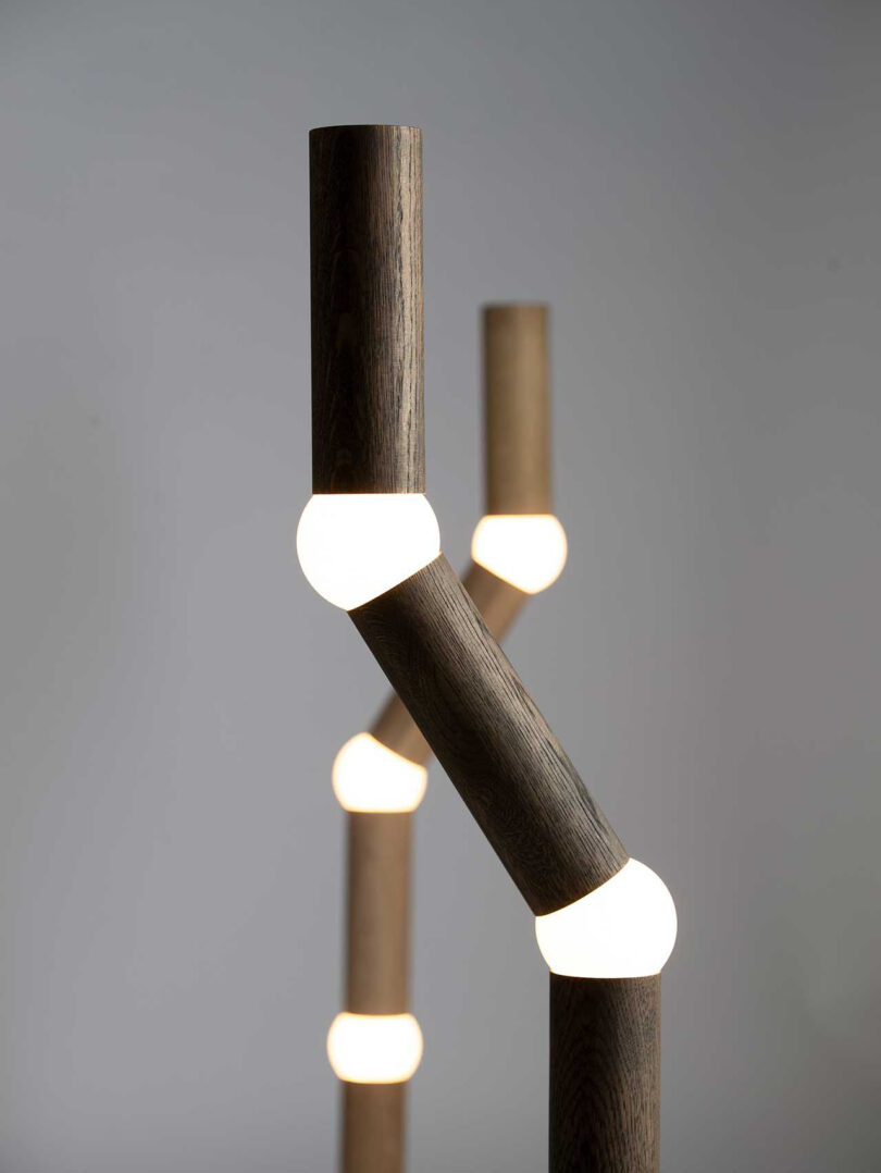 detail of two long, slender floor lamps with four segments, each connected by a round lightbulb