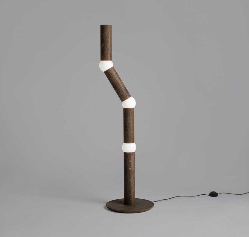 slender floor lamp with four segments, each connected by a round lightbulb