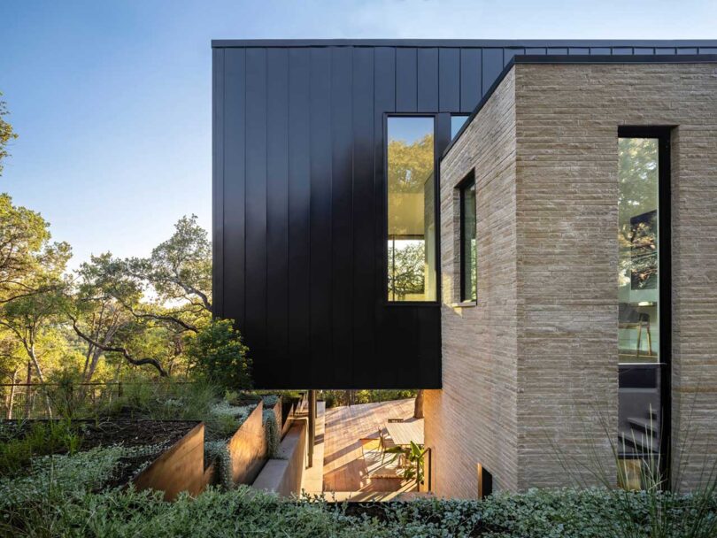 partial edge exterior view of modern house clad partially in stone and in sheet metal