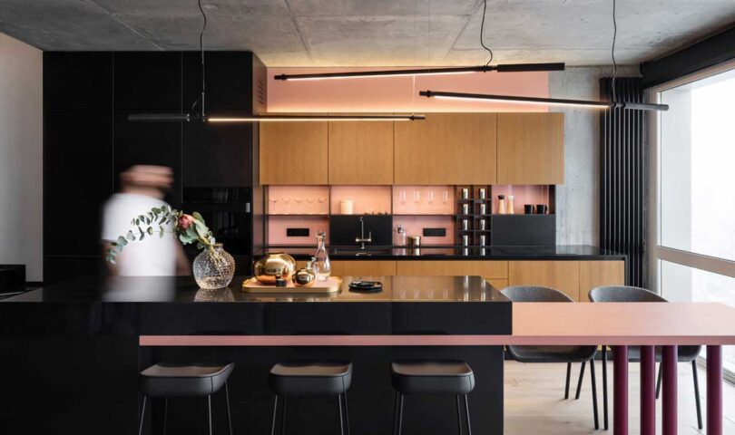 modern black kitchen with pink and wood details