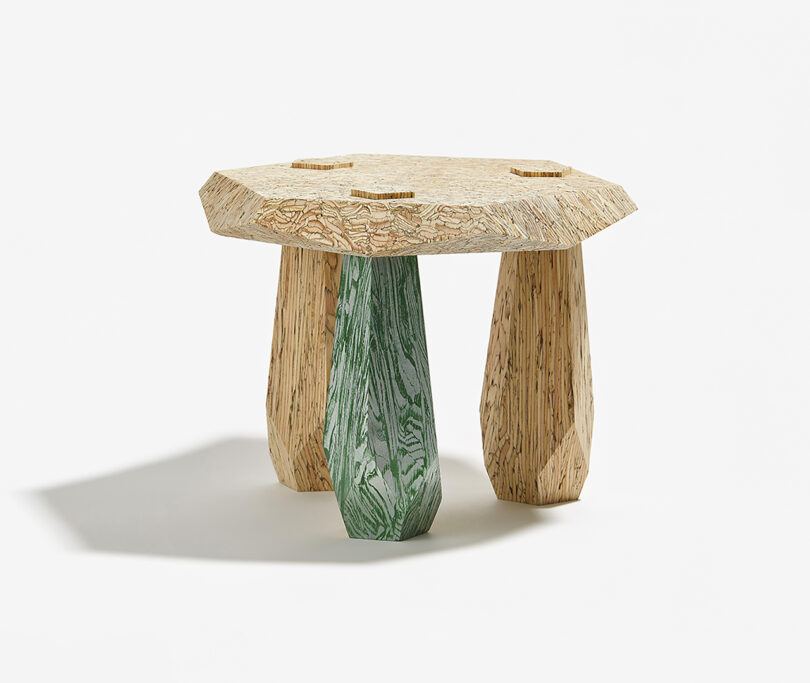 three legged structure with light wood top and green leg