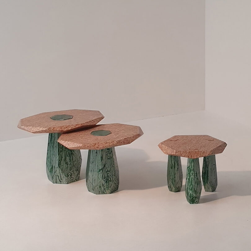 three differently sized structures with light wood tops and green legs