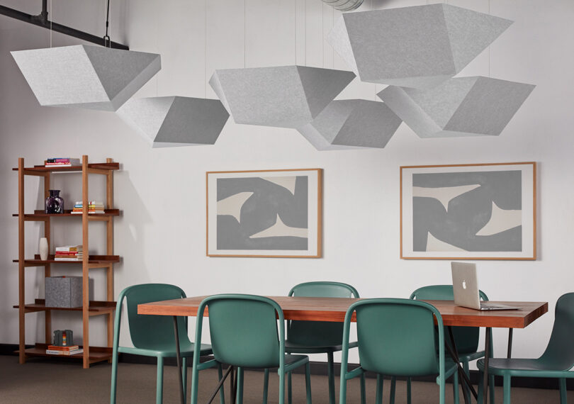 group of white polygon-shaped acoustic pendants in a styled space