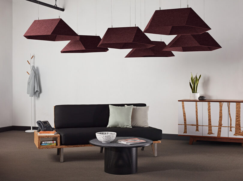group of maroon polygon-shaped acoustic pendants in a styled space