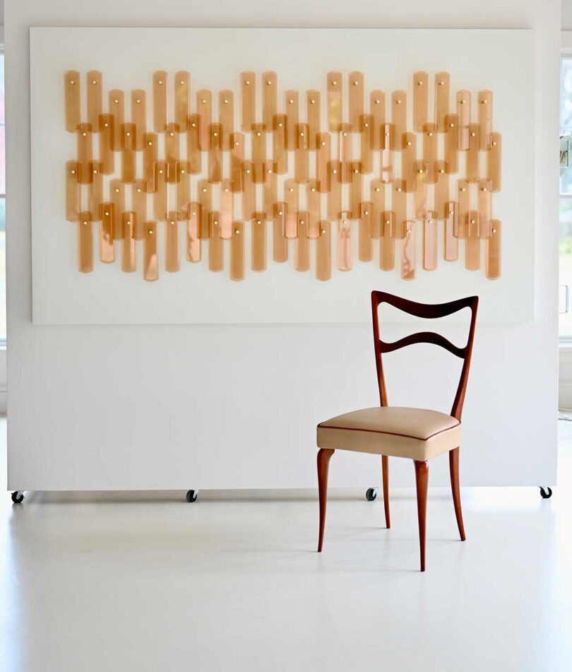 angled chair in front of artwork hanging on wall
