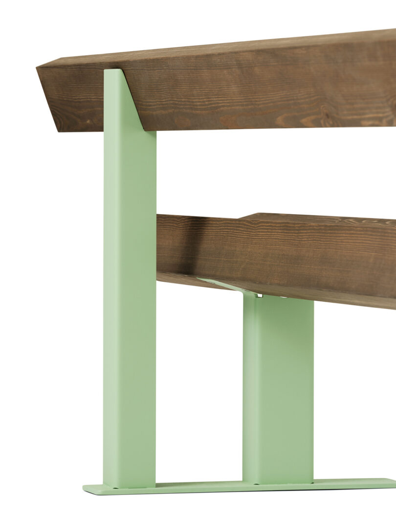 detail of dark wood bench with back and light green metal legs