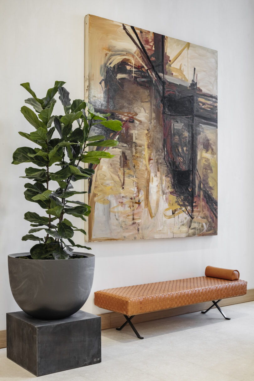 Artwork hung over a leather bench