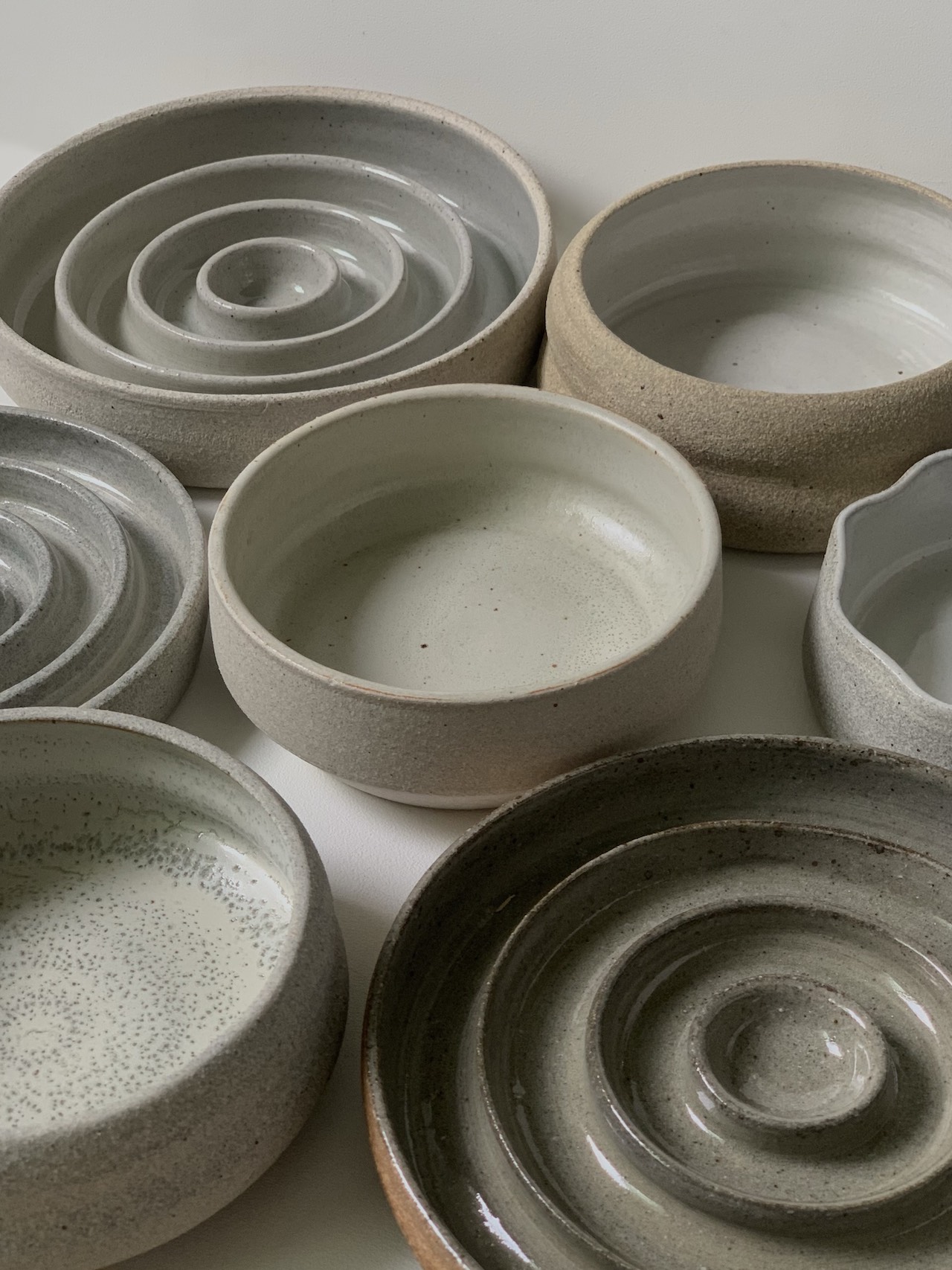 Various ceramic slow feeder bowls and regular bowls for pets for @pawrentceramics on Instagram