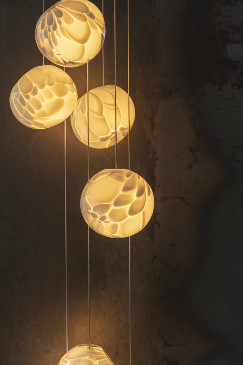string of five globe pendant lights illuminated