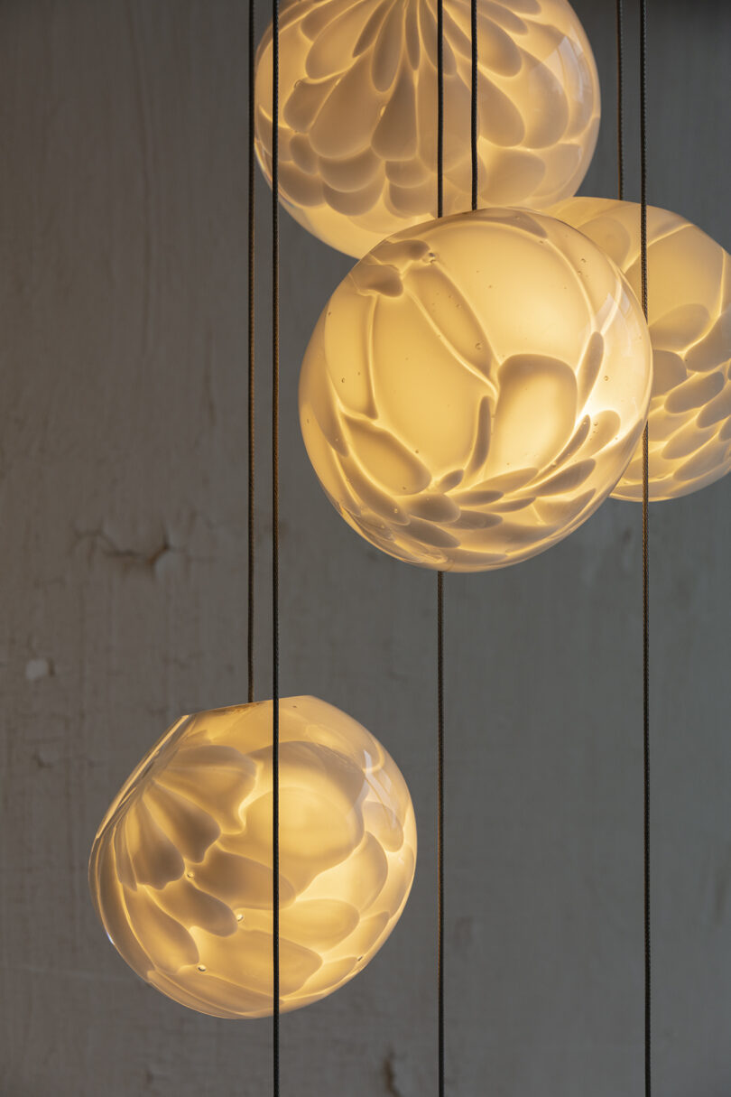 string of four globe pendant lights illuminated
