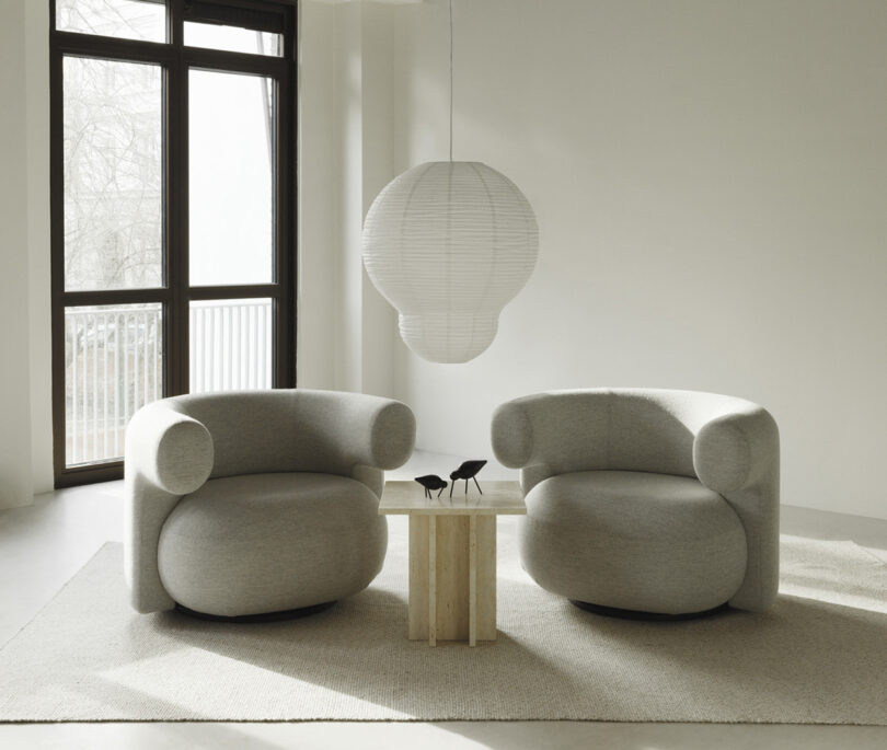 two lounge chairs with a side table in a styled space