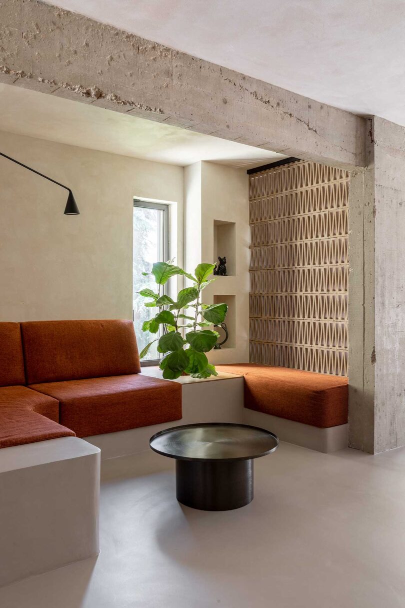 angled view of modern home seating area with built-in sofa with rust colored fabric