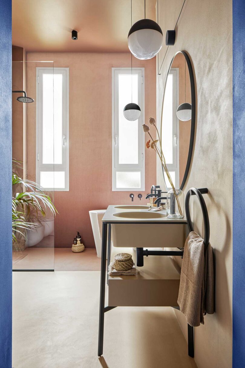 view into modern bathroom with pale pink walls and white fixtures