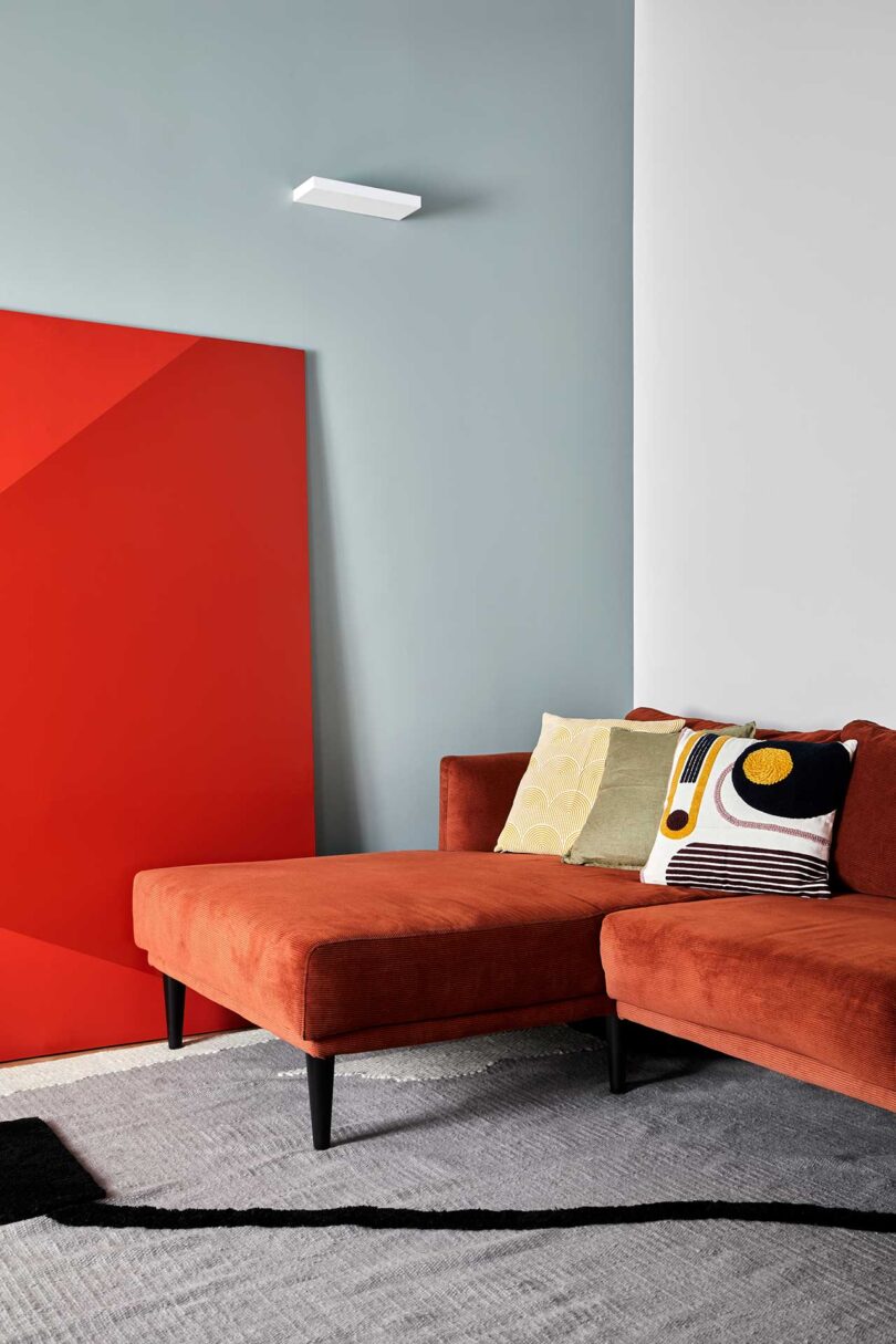angled living room view of orange velvet sofa with lounger