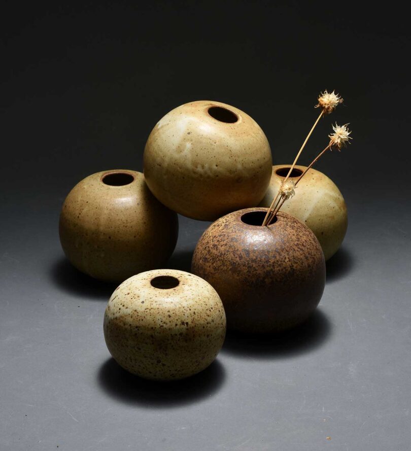 series of small round brown and earthy green vases