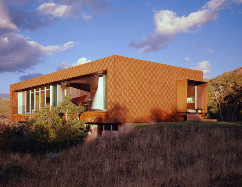 boxy light brown building blending in with the surrounding canyon growth
