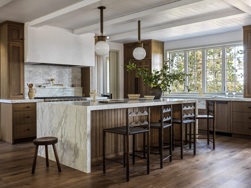 styled kitchen with island, pendant lights, and wooden stools at the counter