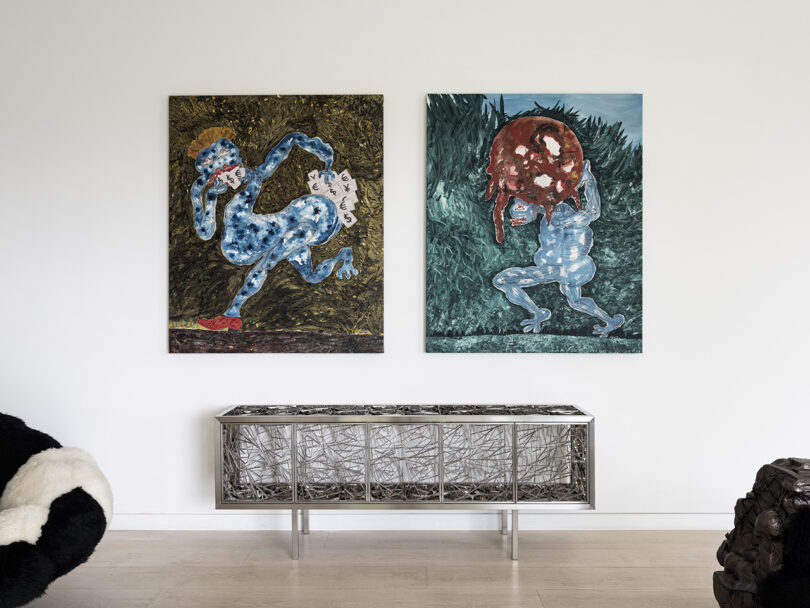 two large paintings hang over a long, low credenza