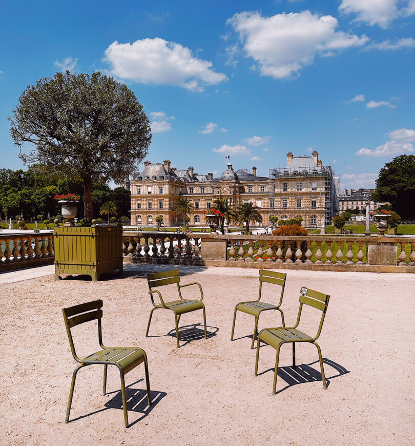 Four empty Fermob’s Luxembourg Collection chairs staged in Paris in Luxembourg Park.