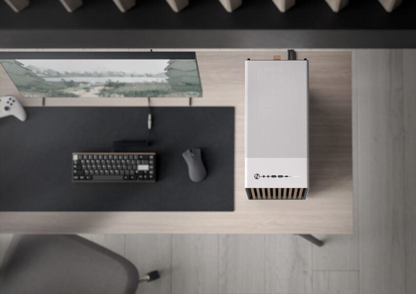 Overhead view of Fractal North PC case set on top of modern wood desk to the right of a keyboard, mouse and monitor in gaming mode.