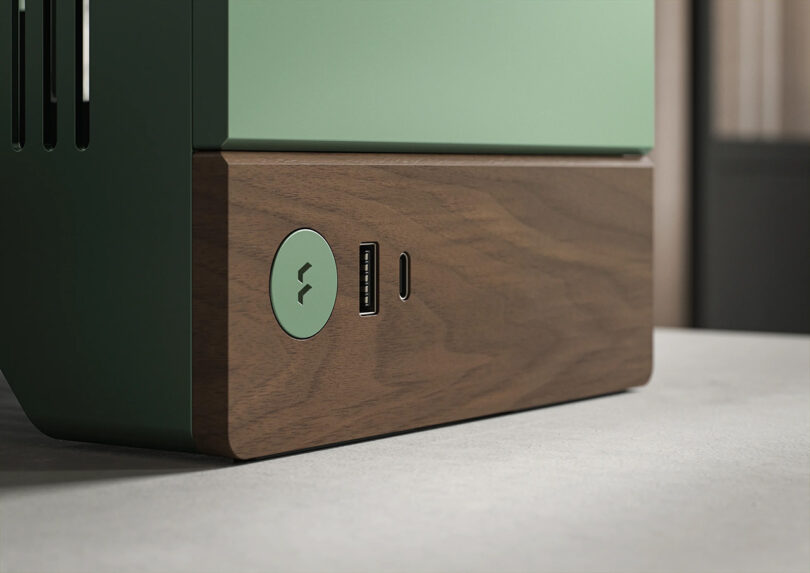 Detail render of aluminum power button and two USB ports for connecting devices are integrated into the walnut wood detailing of the PC case.