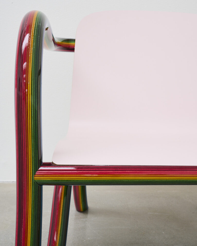 detail of lounge chair with rainbow plywood frame and pale pink seat