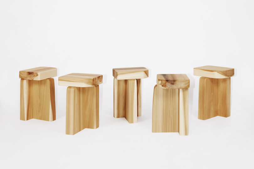 five wooden stools lined up on a white background