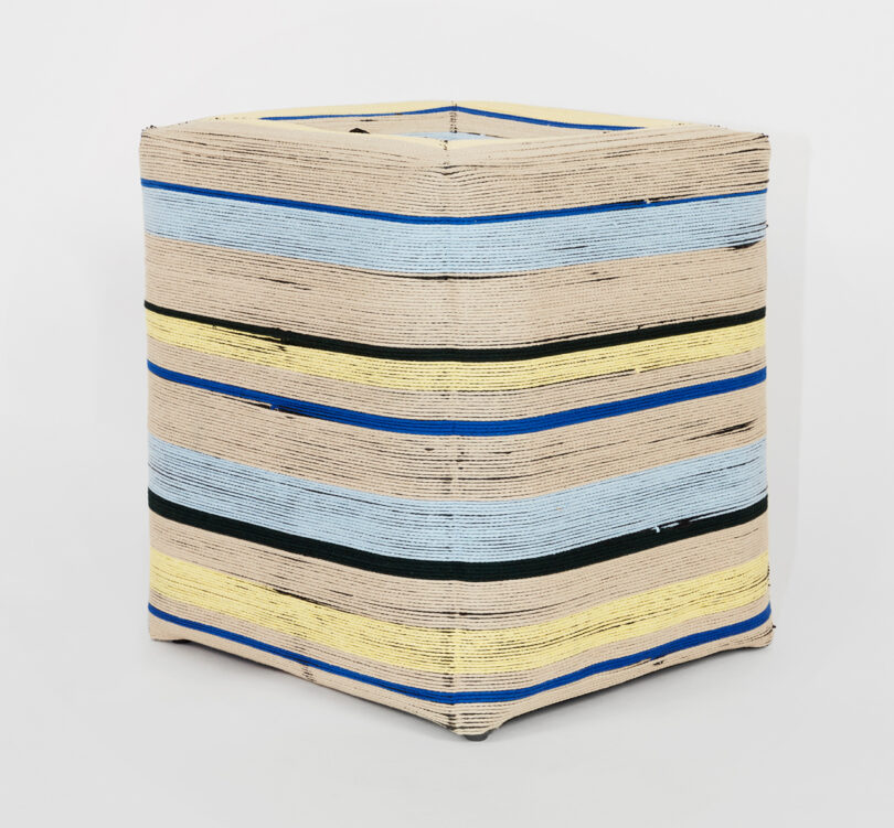square stool with blue, black, yellow, and tan stripes