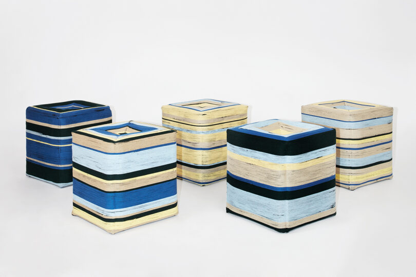 five square stools with blue, black, yellow, and tan stripes