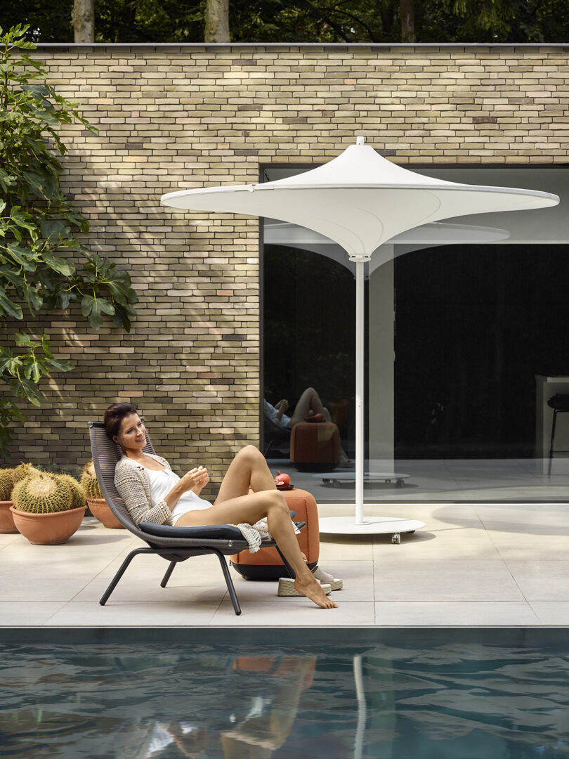 styled outdoor patio with a woman relaxing in a lounge chair and an umbrella