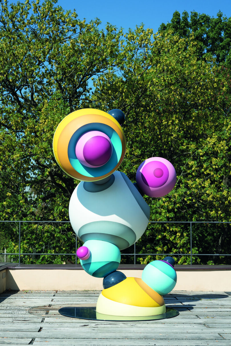 multicolor pastel figure constructed of circles in an outdoor space