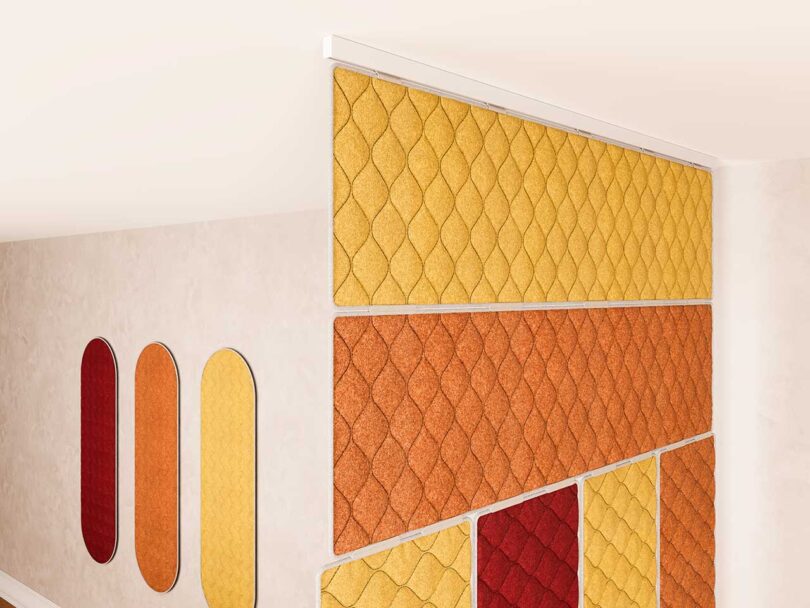 Acoustic panels hung on wall and as room divider in yellows, oranges, and reds