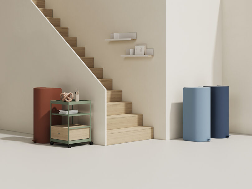 living space with a staircase, side table, and two tall cylindrical garbage cans