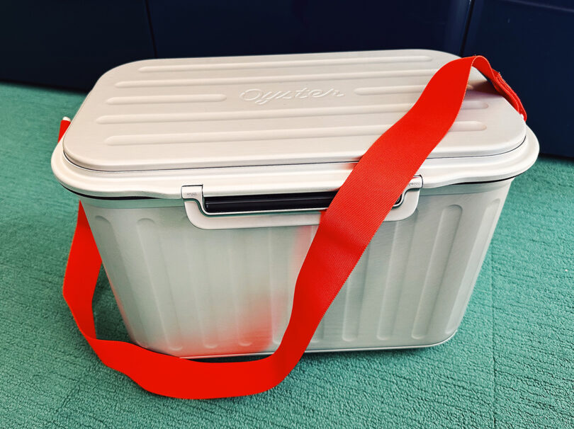 Red shoulder carrying strap attached to Tempo Cooler.