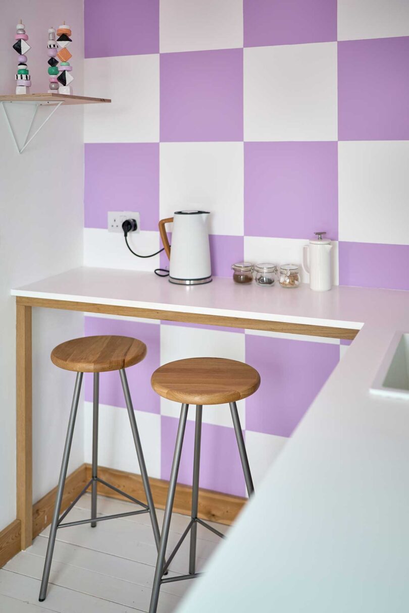 angled view of small kitchen with lavender and white checkered walls and small bar
