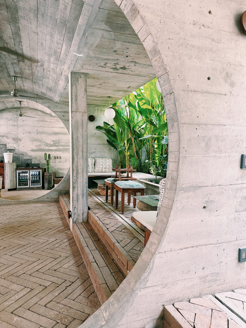 View through circular concrete walkway inside Casa TO hotel poolside lobby.