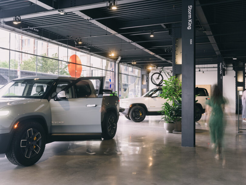 Interior of Rivian Spaces High Line, New York City with parked Rivian R1T and SUV parked inside.