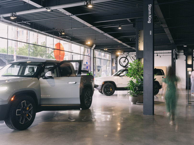 فضای داخلی Rivian Spaces High Line، شهر نیویورک با پارکینگ Rivian R1T و SUV پارک شده در داخل.