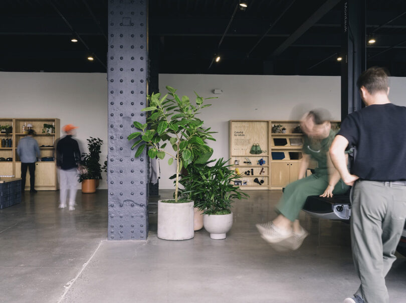 Interior of Rivian Spaces High Line, New York City with parked Rivian R1T truck parked inside with person seated on truck bed door swinging legs. 