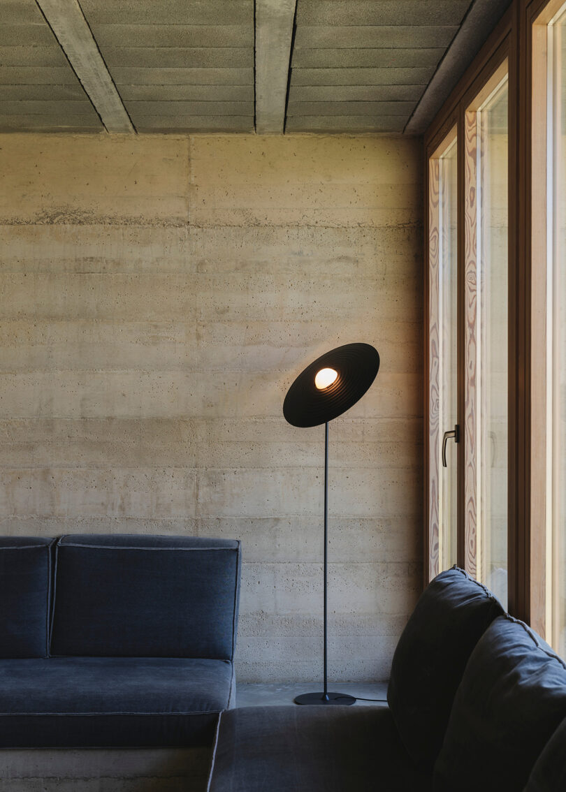 black floor lamp with saucer-shaped shade in a living space