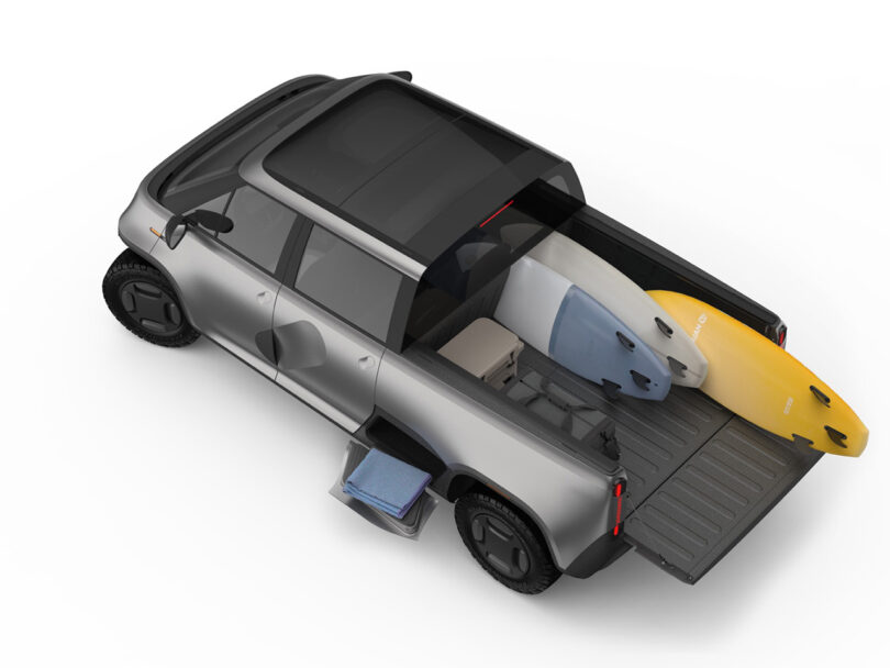Angled overhead view of gray-silver TELO electric truck loaded with surfboards, illustrating truck bed capacity.