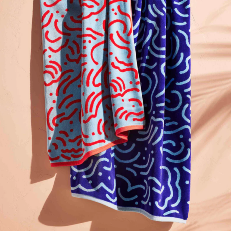 two red and blue beach towels with an abstract contrasting line pattern
