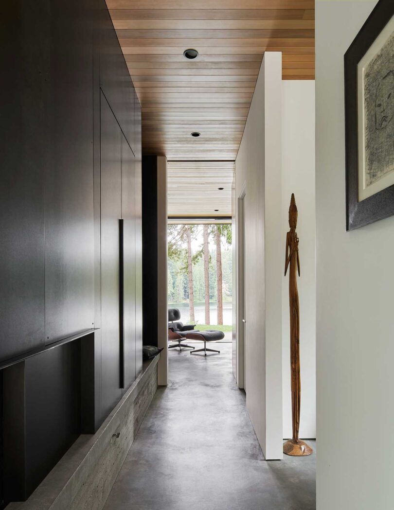 interior shot of modern home hallway into room with lounge chair