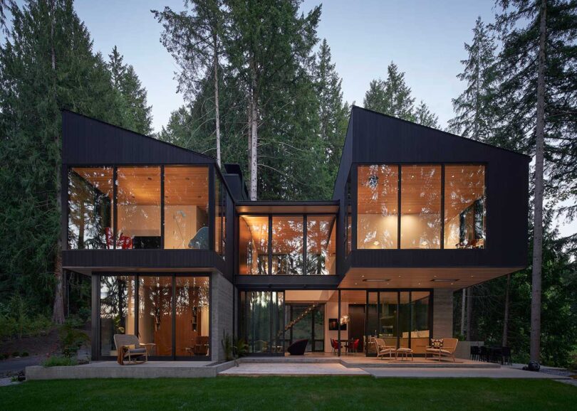 front exterior of modern black and glass house in forest