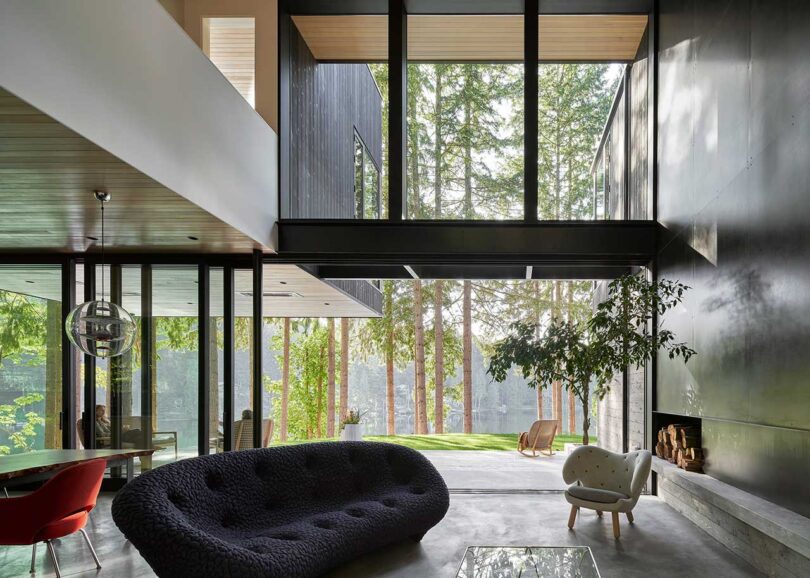 interior shot of modern living room with double height ceiling and wall of windows and modern furnishings